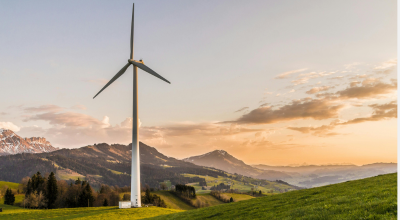 Atardecer con molino de viento en un monte 