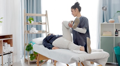 Fisioterapeuta con un cliente en la camilla