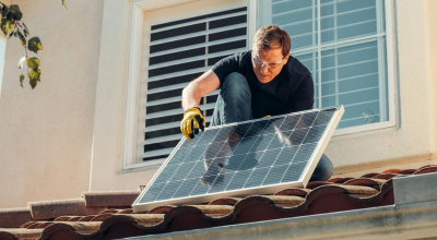 Hombre poniendo paneles solares en tejado