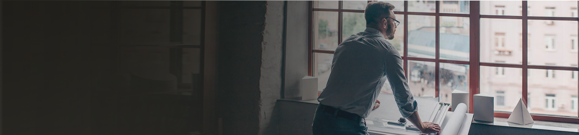 Hombre mirando por la ventana de su oficina