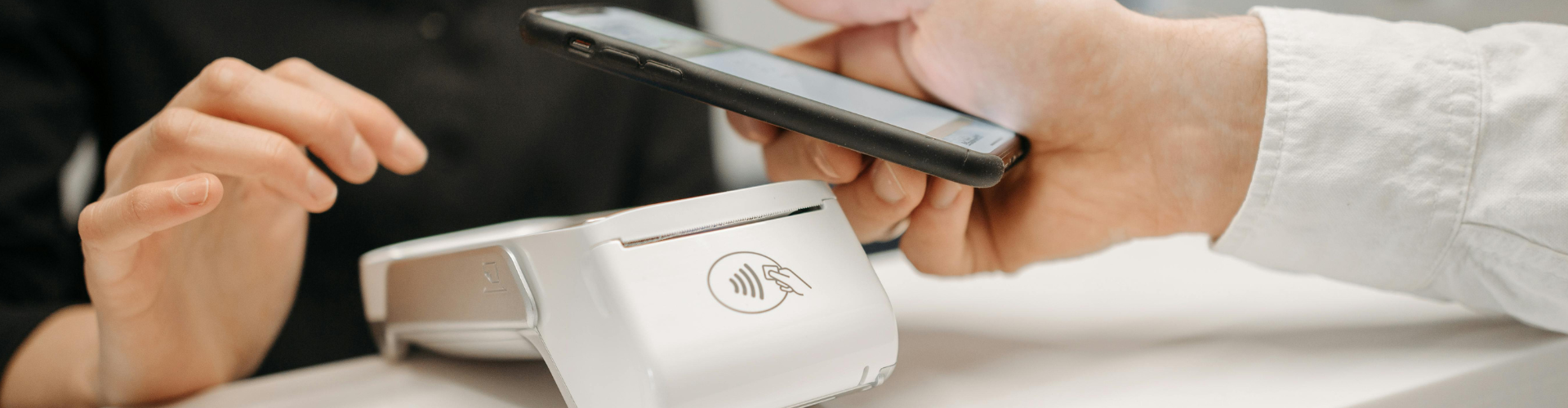 Primer plano de móvil pagando en TPV