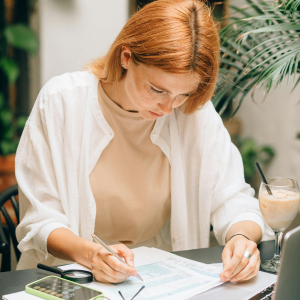 Mujer pelirroja mirando sus facturas
