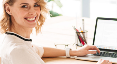Mujer con ordenador mirando a cámara
