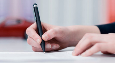 Manos firmando papeles