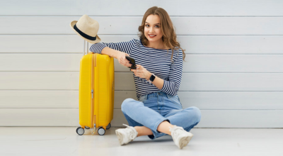 Chica sentada en el suelo con una maleta amarilla
