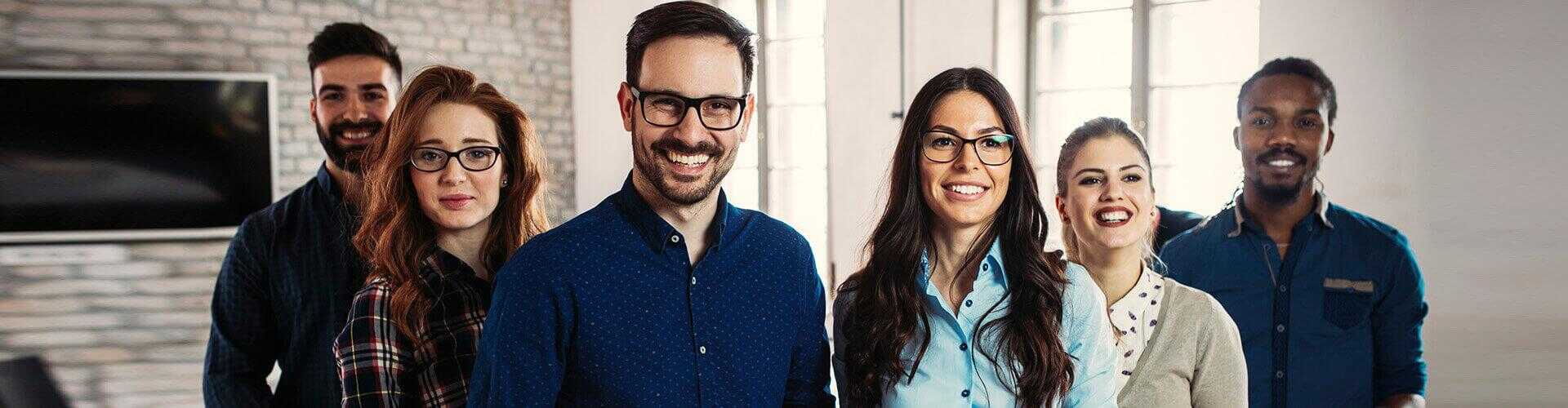 Equipo sonriendo unas personas al lado de otras