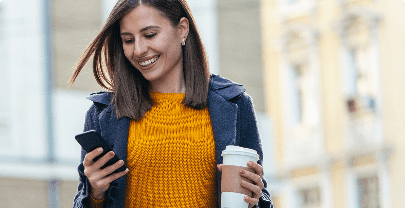 Mujer comprando con el móvil y un café