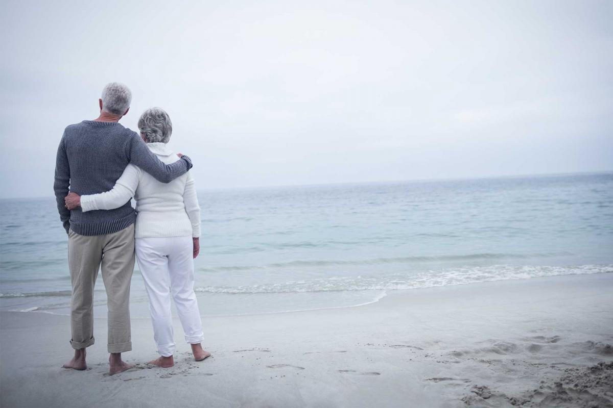 Pareja de ancianos abrazándose en la playa