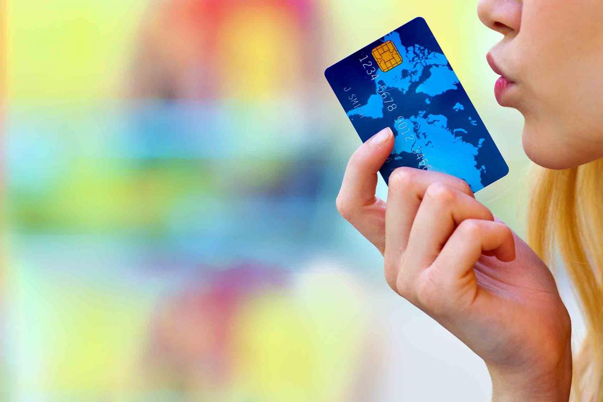Mujer soplando tarjeta de crédito Mujer soplando tarjeta de crédito