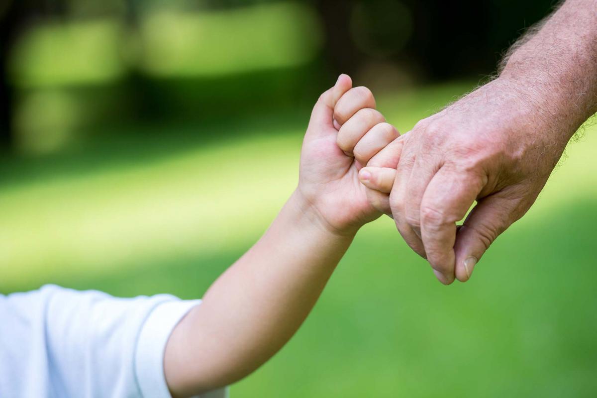 Mano adulta sujetando la mano de un niño Mano adulta sujetando la mano de un niño