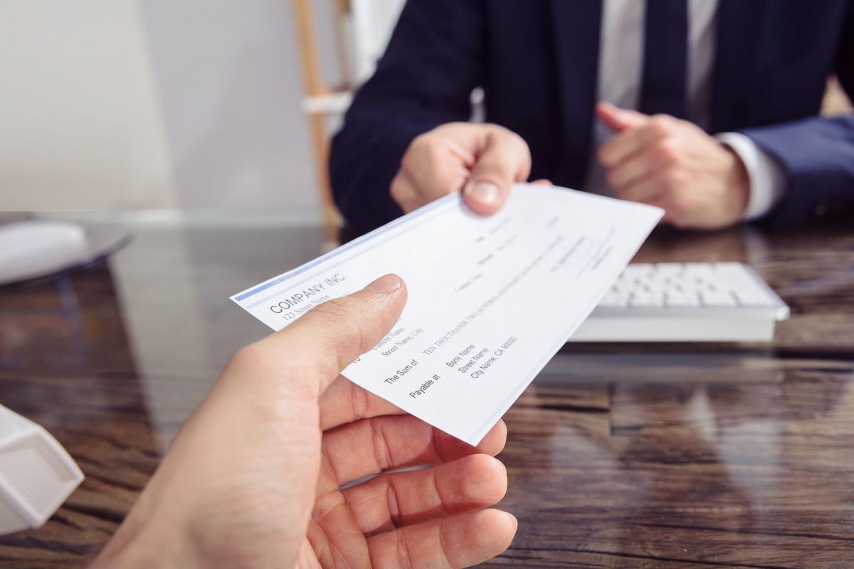 Hombre entregando un cheque