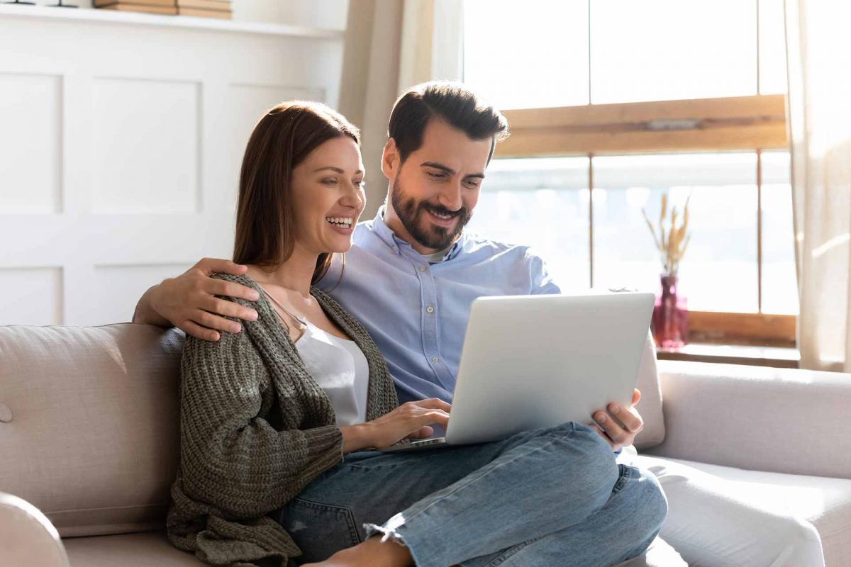 Pareja mirando al ordenador en el sofa