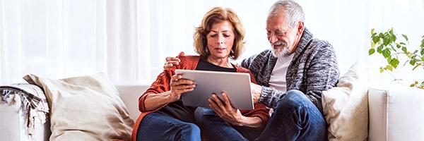 Programa Te lo Mereces Pensión - Una pareja jubilada relajada en casa utilizando una tableta digital